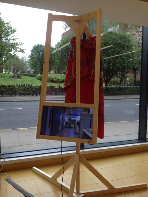 Amy Pickles’ video piece, with red printed cape behind. Image credit: Debbie Nicol